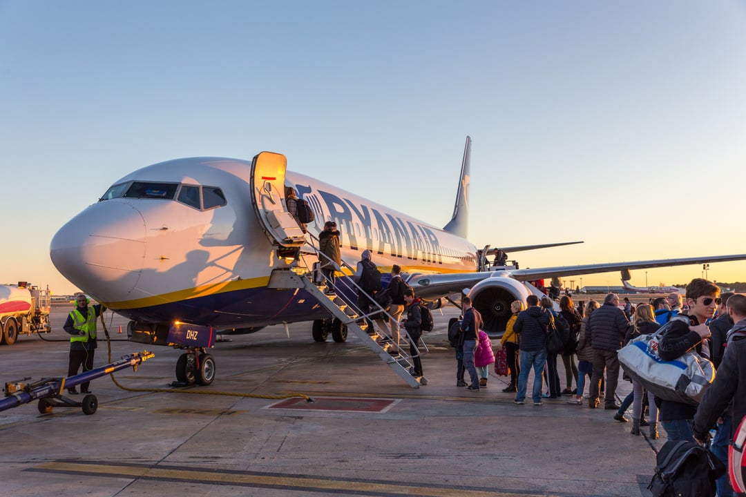 People Boarding on Ryanair Jet Commercial Airplane on Valencia Airport at Sunset